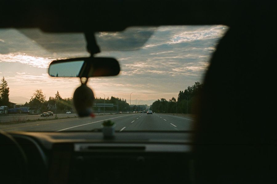 The view through a car windscreen on a highway at sunset