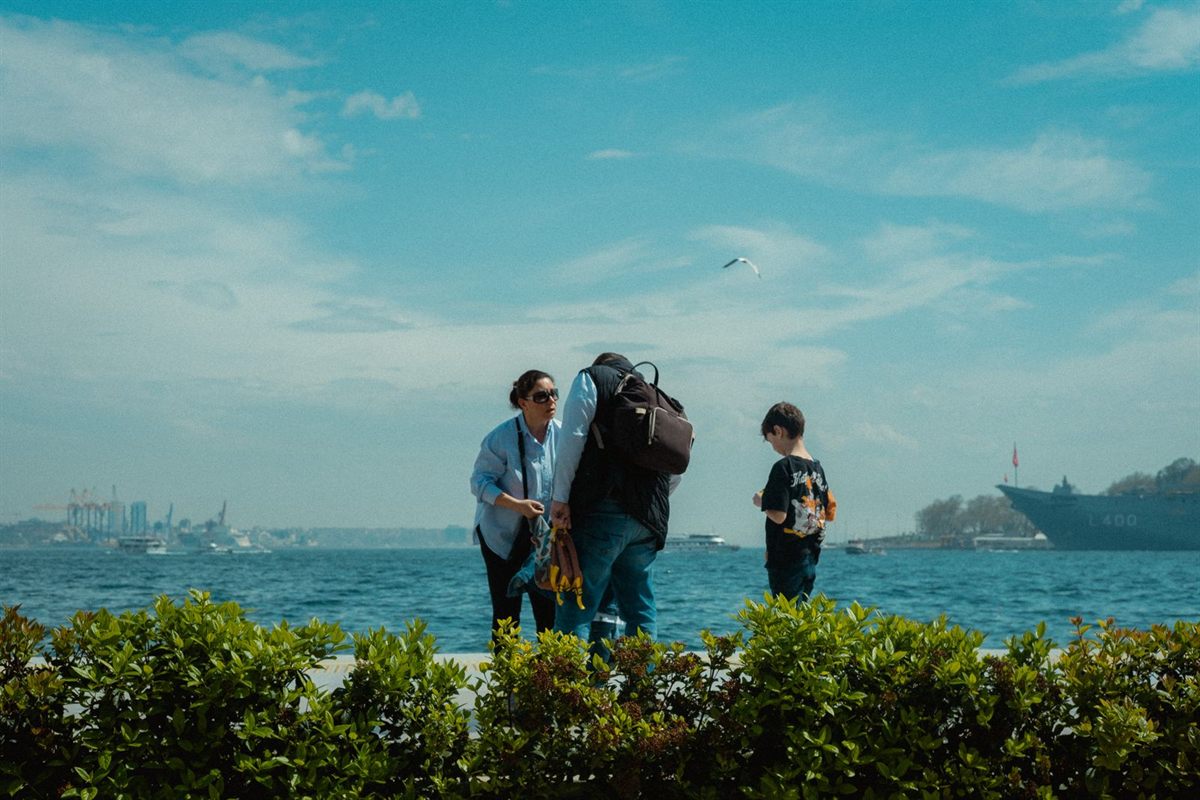 A family looking out over the sea with ships in the distance