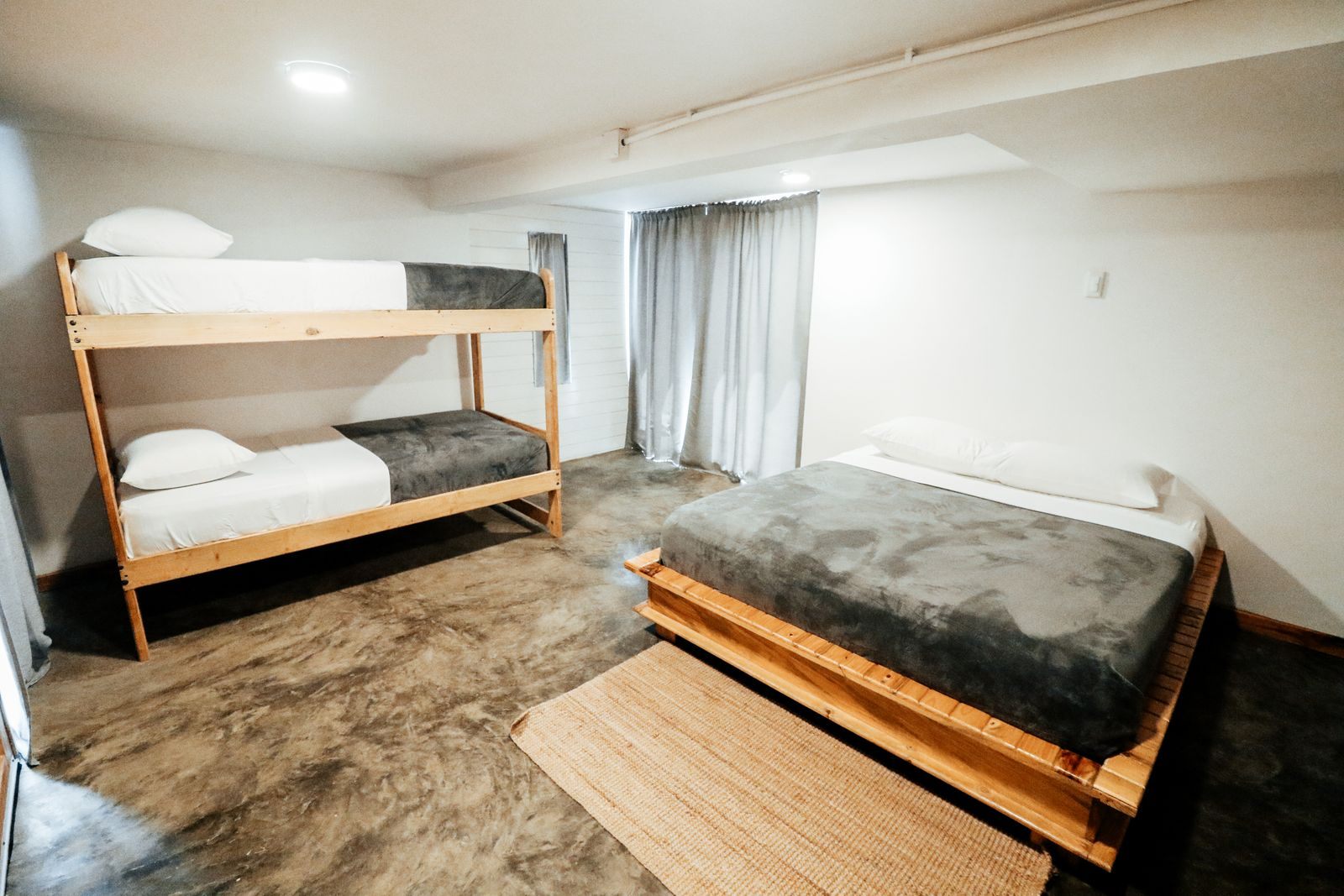 A wooden bunk bed beside a double bed, the kind of four-berth layout a quad cabin cruise uses