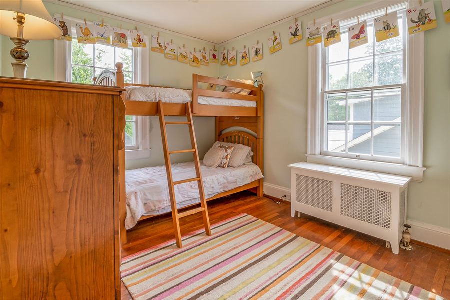 A cosy bedroom with a wooden bunk bed under a window